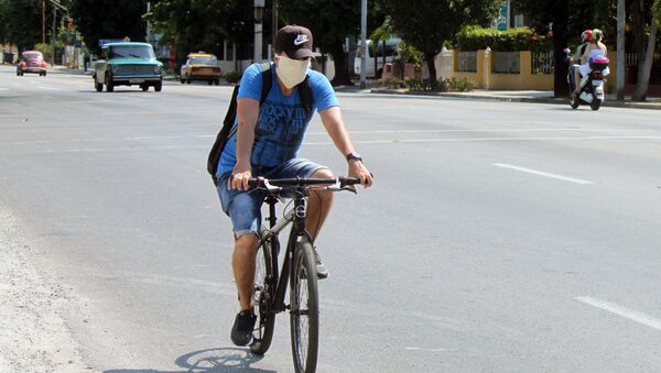 Un ciclista en mascarilla en Cuba - Sputnik Mundo