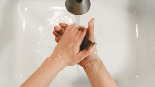 Una persona se lava las manos - Sputnik Mundo