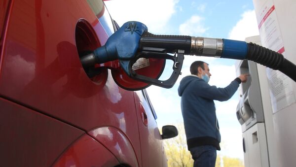 Un hombre tanquea el coche en una gasolinera - Sputnik Mundo