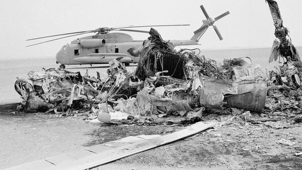 Restos de un helicóptero estadounidense quemado frente a un helicóptero abandonado en Irán, el 27 de abril de 1980 - Sputnik Mundo