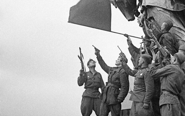 Soldados del batallón comandado por Stepán Neustróyev saludan en el techo del Reichstag - Sputnik Mundo