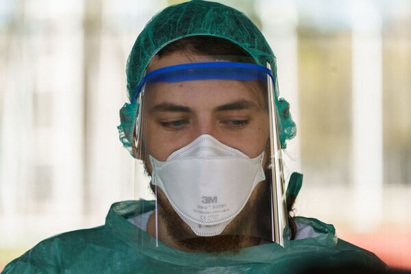 A healthcare worker dressed in protective gear  - Sputnik Mundo