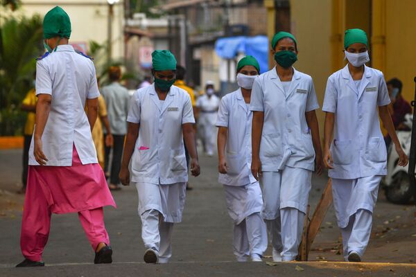 A nurse (L) arrives as others leave at the end of their shift at the King Edward Memorial (KEM) hospital in Mumbai - Sputnik Mundo