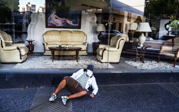 Hombre sin hogar frente a un negocio de diseño de interiores en pleno aislamiento obligatorio. Buenos Aires, Argentina.  - Sputnik Mundo