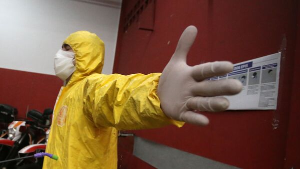 Una persona en el traje de protección durante la pandemia de coronavirus en Brasil - Sputnik Mundo