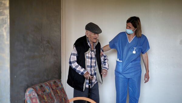 Una enfermera ayuda a un anciano en Francia - Sputnik Mundo