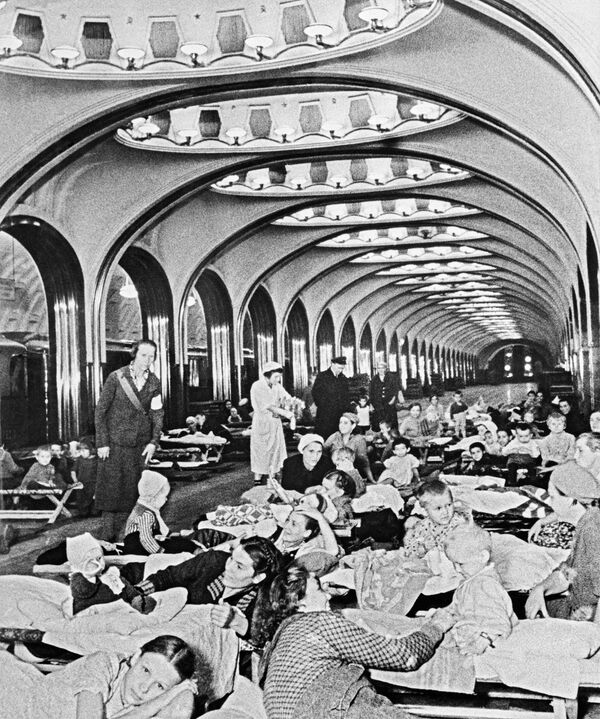 Mujeres y niños durante el refugio de alerta antiaérea en el metro Mayakóvskaya de Moscú, 1941. - Sputnik Mundo
