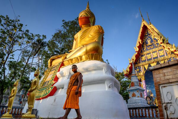 Una estatua gigante de Buda con una mascarilla en un templo de la provincia de Pathum Thani, en Tailandia.  - Sputnik Mundo