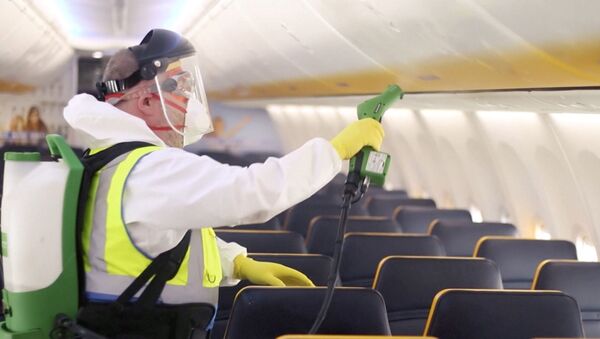 Un hombre desinfecta el interior de un avión de Ryanair - Sputnik Mundo