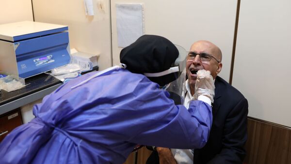 Un paciente haciendo un test por coronavirus en Irán - Sputnik Mundo