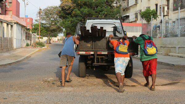 Unos chicos empujan un camión que se quedó sin gasolina durante la crisis de combustible en Venezuela - Sputnik Mundo