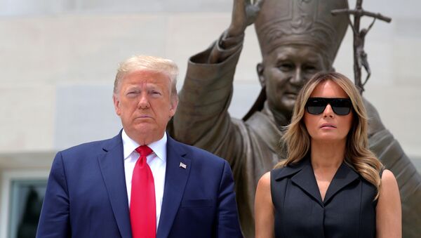 El presidente de Estados Unidos, Donald Trump, y la primera dama, Melania Trump, están frente a una estatua del papa Juan Pablo II - Sputnik Mundo
