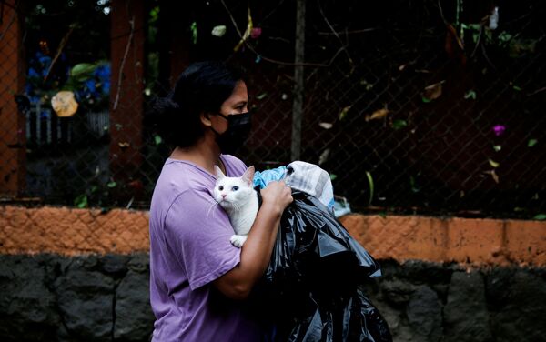 Женщина в защитной маске и с котом во время наводнения, вызванного тропическим штормом Аманда в Илопанго, Сальвадор - Sputnik Mundo