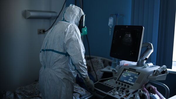 El personal médico lleva un traje protector en un hospital ruso para pacientes con COVID-19 - Sputnik Mundo