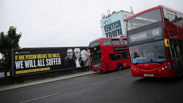 Una pancarta con las imágenes de Michael Gove, Dominic Cummings y Boris Johnson en Londres - Sputnik Mundo
