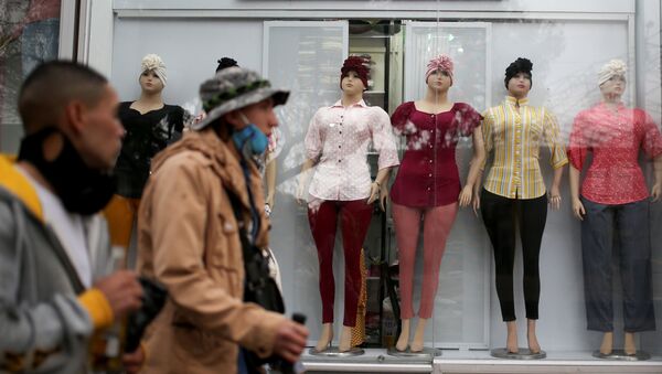 Colombianos caminan frente a tienda de ropa en Bogotá - Sputnik Mundo