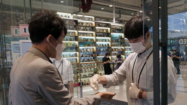 Dos hombres con mascarillas en Seúl durante la segunda hola del coronavirus en Corea del Sur - Sputnik Mundo
