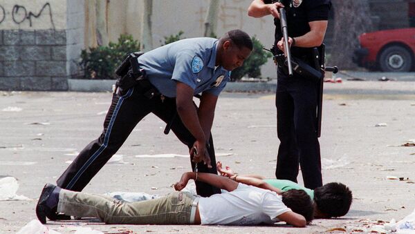 Un agente de Policía detiene a dos sospechosos de saqueo durante los disturbios de Los Ángeles - Sputnik Mundo