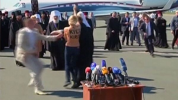 Mujer semidesnuda se abalanza sobre patriarca Ortodoxo de Rusia en el aeropuerto de Kiev - Sputnik Mundo