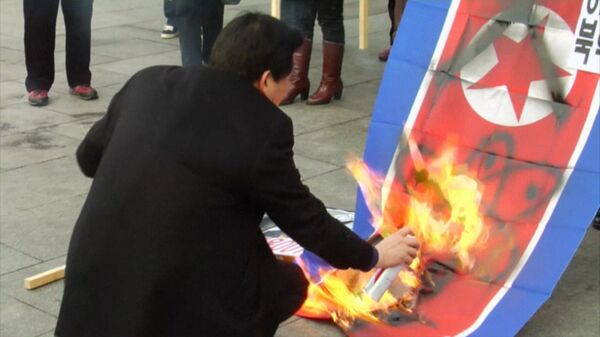 Activistas queman bandera de Corea del Norte en Seúl en protesta por la prueba nuclear - Sputnik Mundo