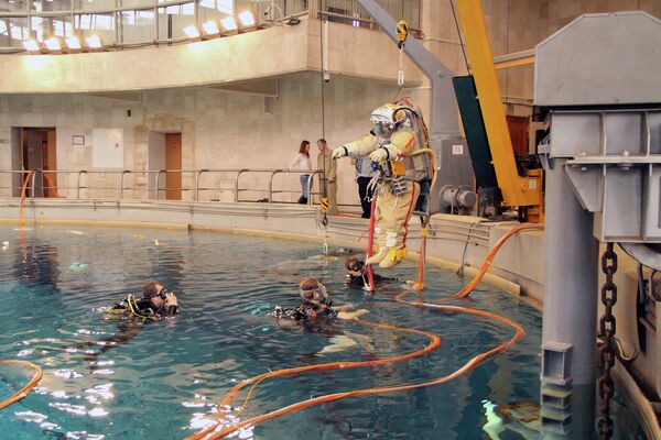 Una grúa eleva al cosmonauta para sumergirle en la piscina de entrenamientos - Sputnik Mundo
