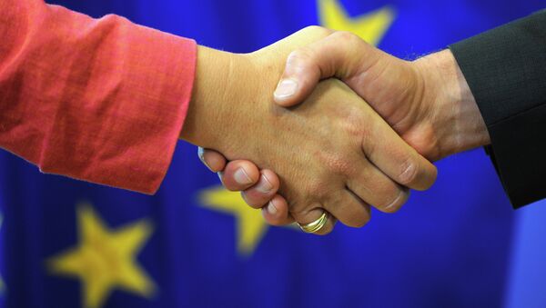 Apretón de manos con la bandera de la UE de fondo - Sputnik Mundo