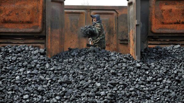 Un trabajador descarga carbón australiano en una estación de tren en Shenyang, China - Sputnik Mundo